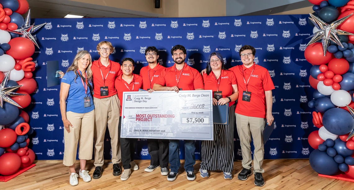 A mixed group of people hold a large check.