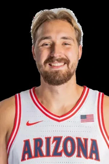 A man in a basketball jersey smiles.