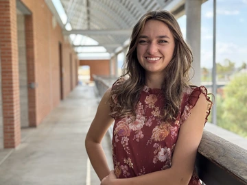A woman with brown hair wears a red shirt.