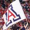 A white flag with a big red and blue A pictured in front of a crowd of students.