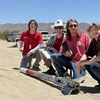 Students from the Wildcat Rocket Engineering Club pose with their rocket in the desert